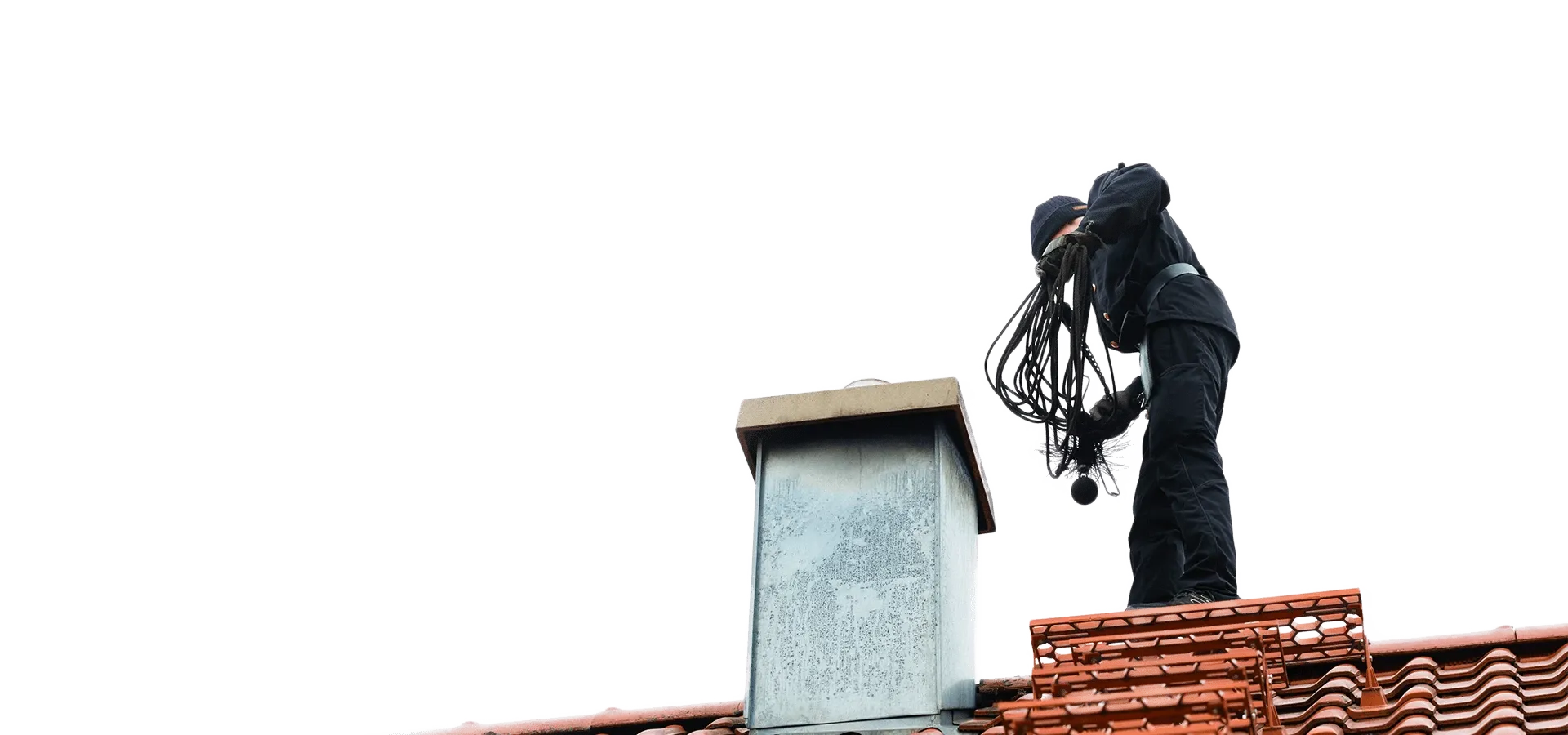 Kominiarz zakładu Sprindt pracujący przy kominie na dachu